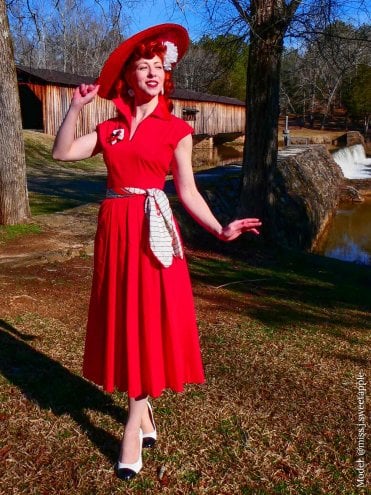 Red 1940s Runaround Sue day dress with winged collar and pockets